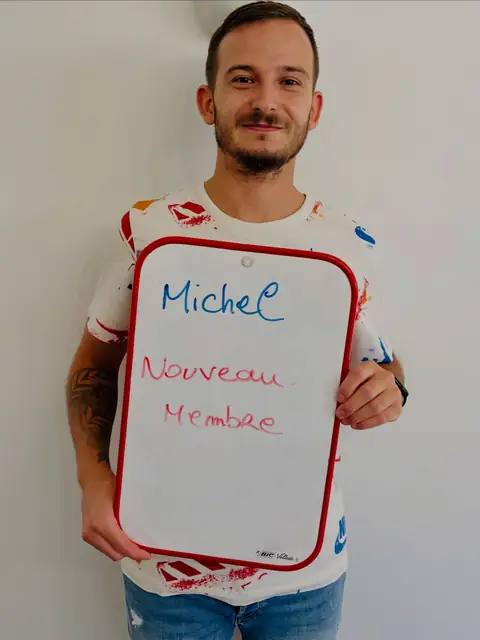 Un membre rayonnant dévoile, sur son ardoise, le résultat de son bilan au club
