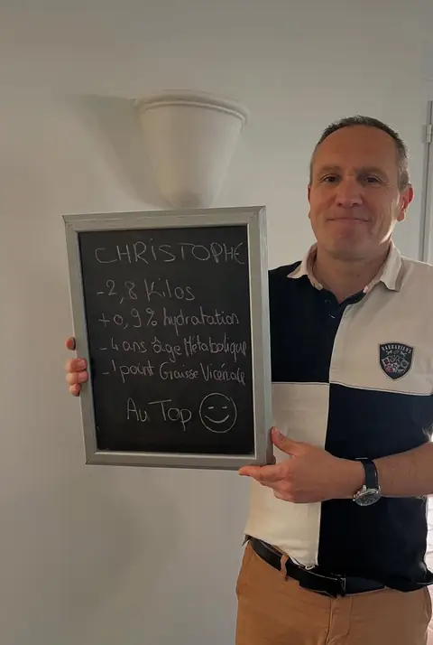 Une ardoise blanche, un bilan écrit dessus, un membre qui le présente depuis la salle du club